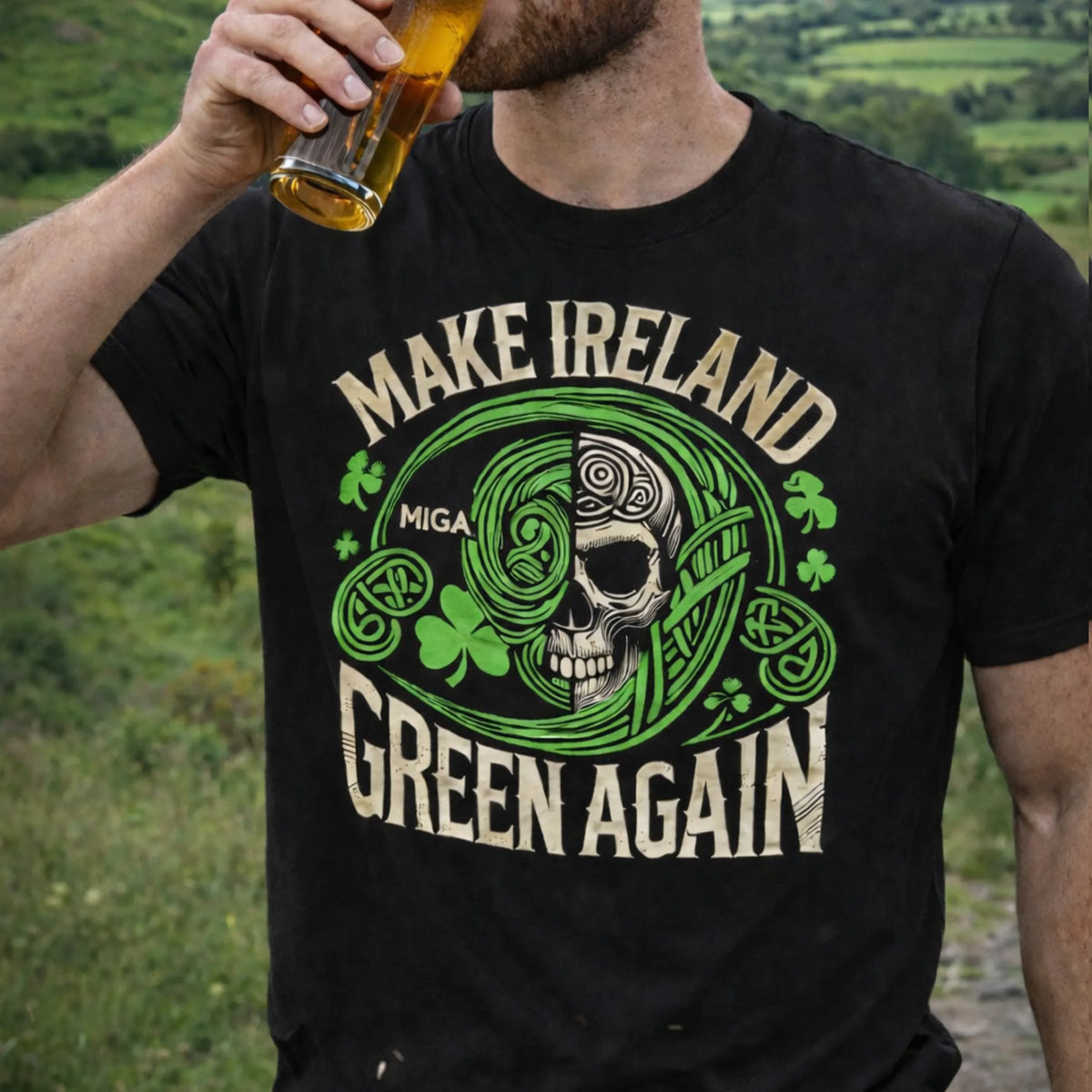A person in a black Emerson Knives, Inc. MIGA T-Shirt featuring a skull, shamrocks, Celtic designs, and "MAKE IRELAND GREEN AGAIN" drinks from a glass with a green landscape in the background.