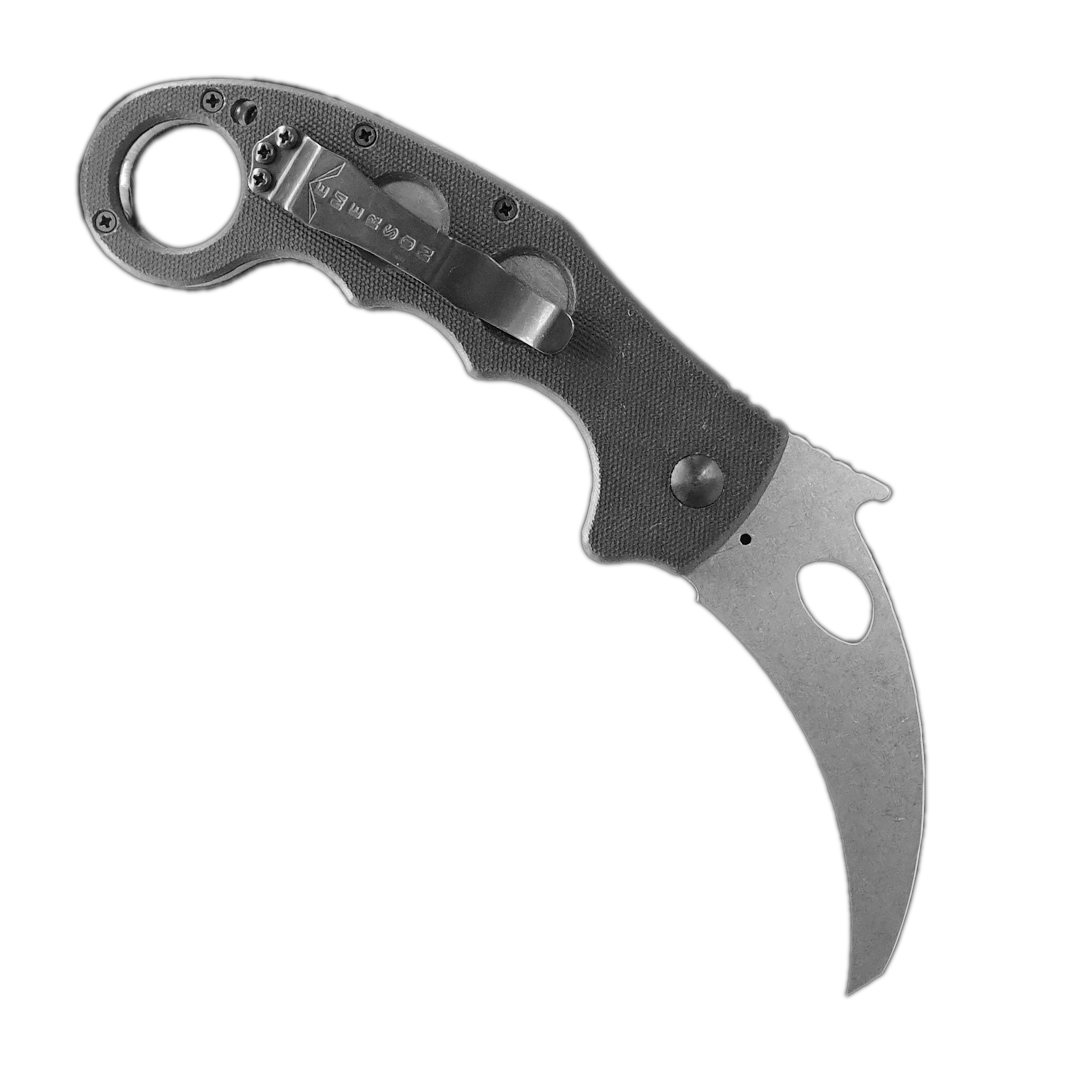 The Emerson Knives, Inc. Super Karambit is a folding knife featuring a black handle with circular cutouts, a curved silver blade, and a finger ring at the end—ideal for defense.
