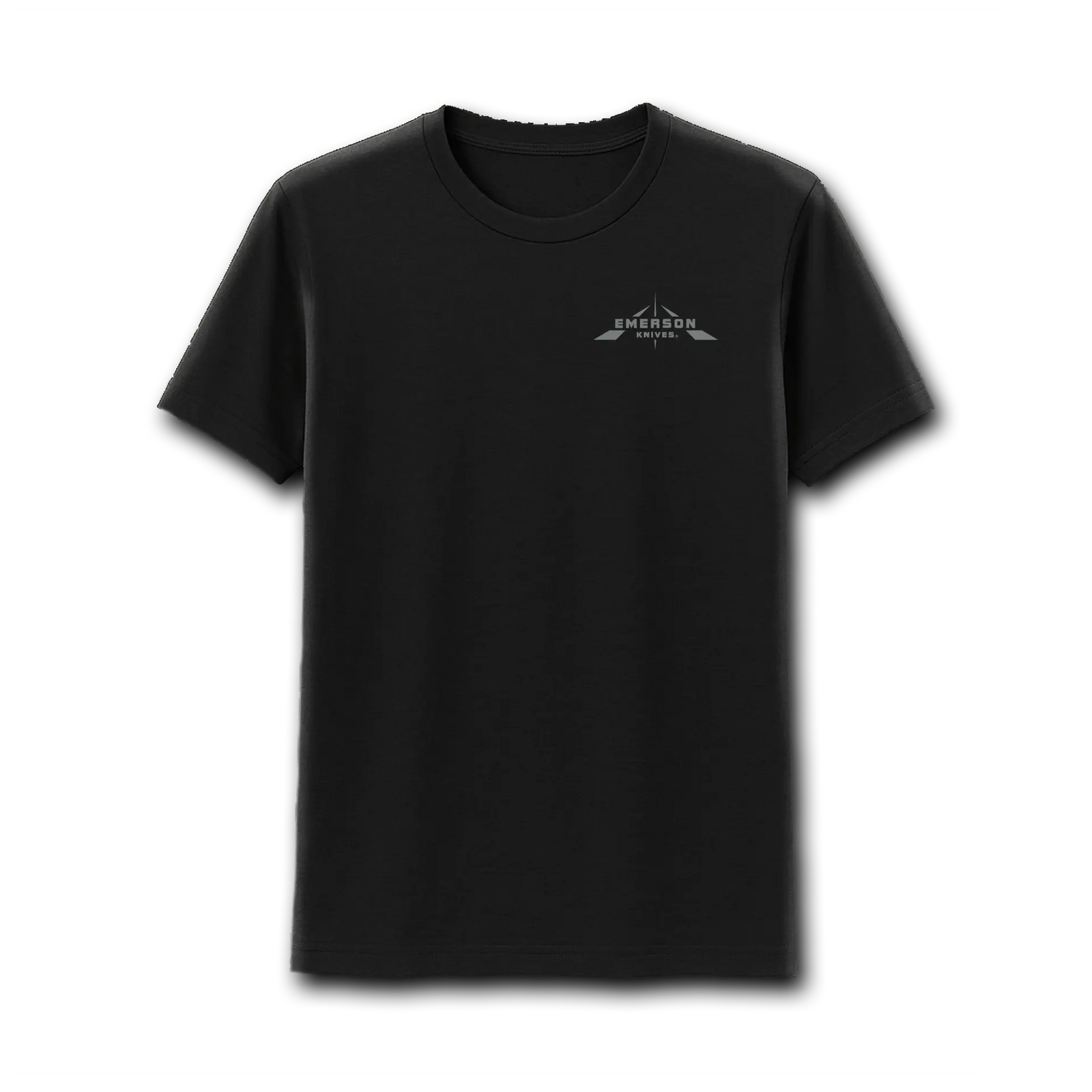 A man stands outdoors in a canyon wearing the Emerson 3.0 T-Shirt by Emerson Knives, Inc., which features a large skull logo and “EMERSON KNIVES U.S.A. EST. 1979” on the back, with rocky cliffs and greenery in the background.