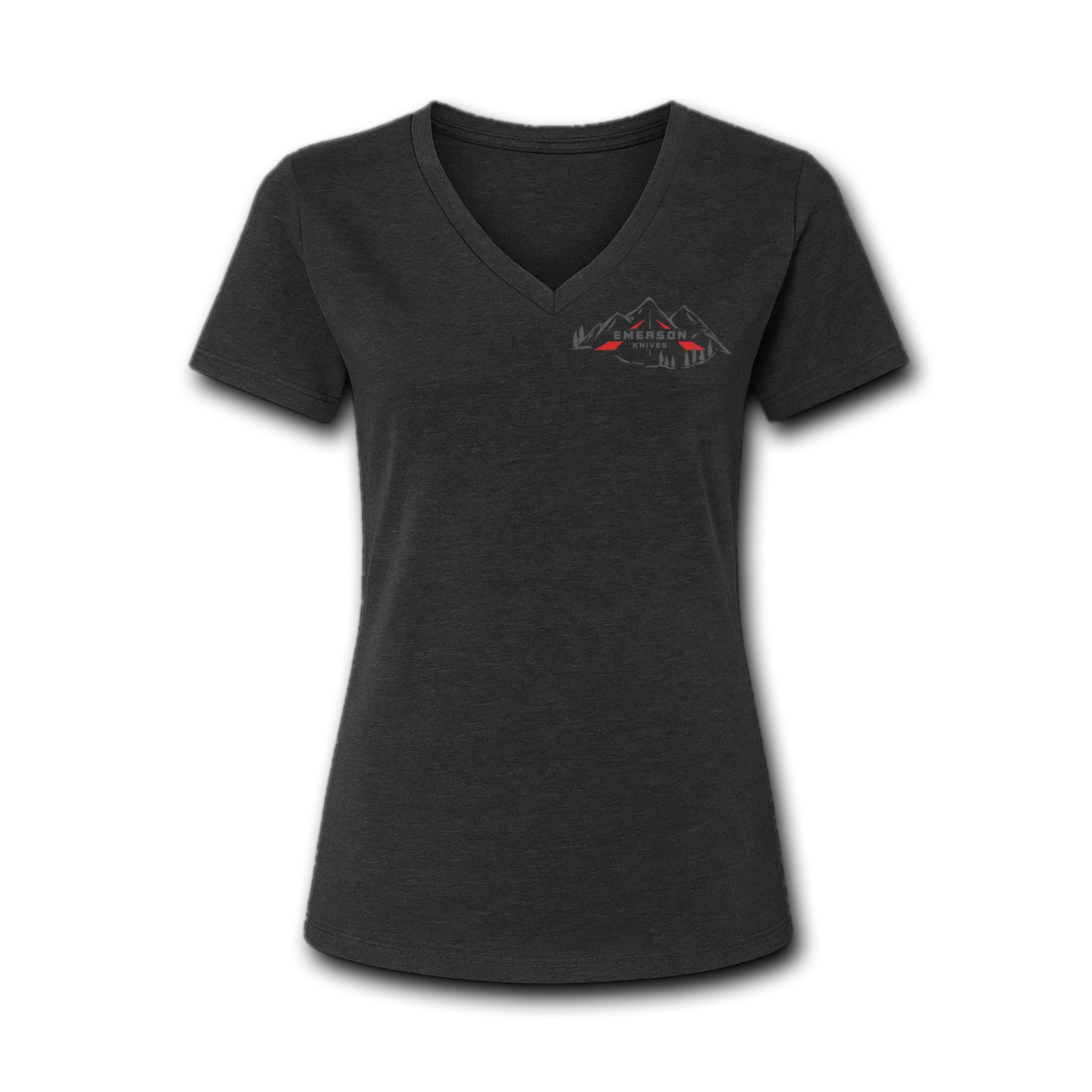 A woman stands outdoors near a campfire and tent, wearing the Emerson Knives, Inc. Women's Backcountry V-Neck T-Shirt featuring a mountain and trees graphic on the back, with tall pine trees in the background.