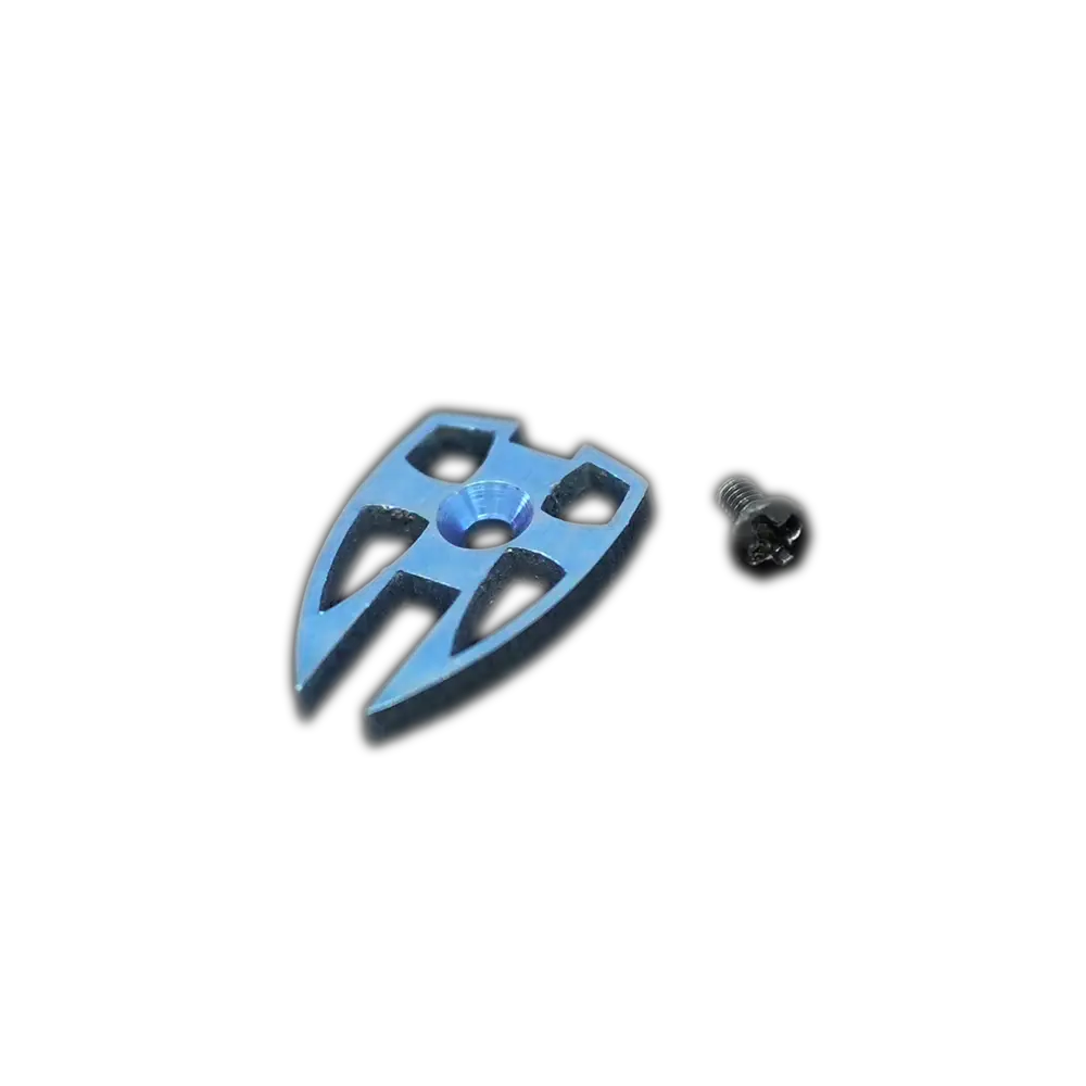 The Emerson Knives, Inc. Crusader Shield Thumb Button, a metal arrowhead-shaped clip with cut-out sections, is displayed alongside a small matching screw on a white background.