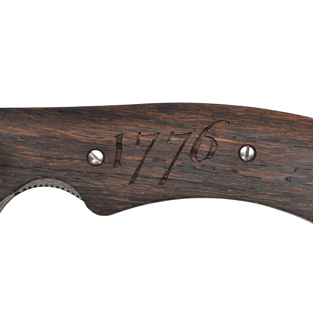 Close-up of a dark wooden gun handle engraved with the number 1776 and secured with two metal screws against a white background.